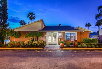 Park Avenue Apartments Tampa Florida Clubhouse Exterior with Trees and Blue Glowing Sky in Background