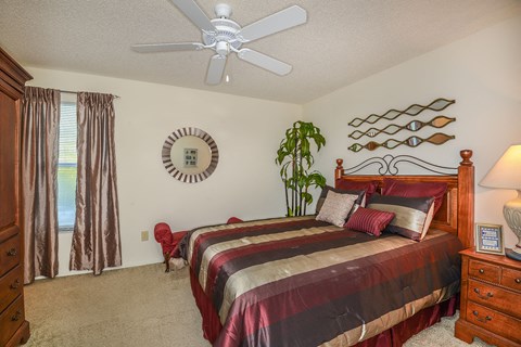 a bedroom with a bed and a ceiling fan