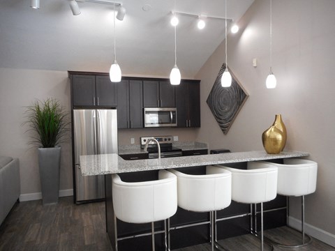 a kitchen with white chairs and a granite counter top