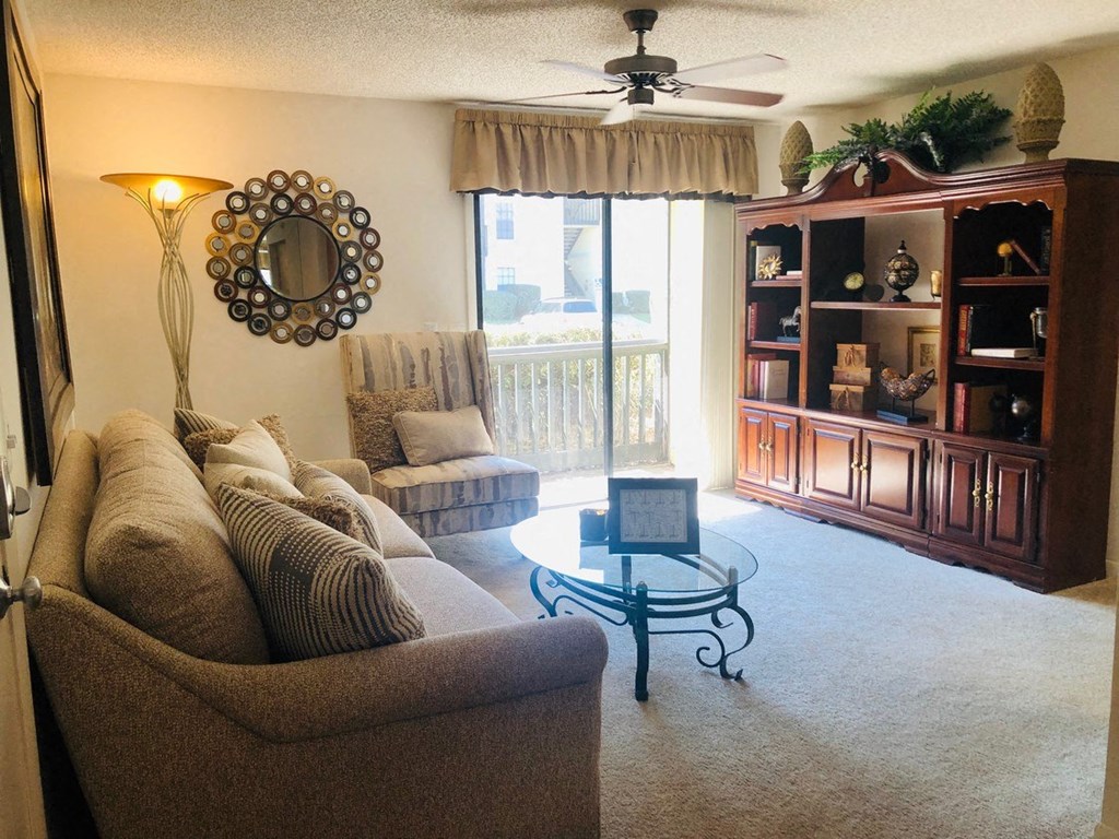 a living room with a couch and a ceiling fan