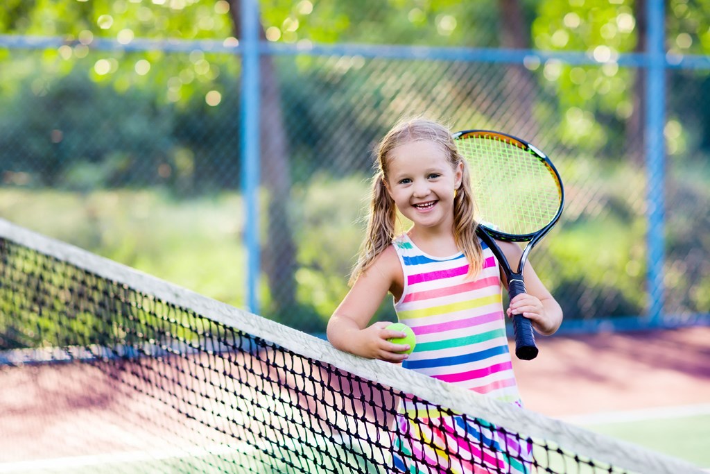 little girl playing tennis