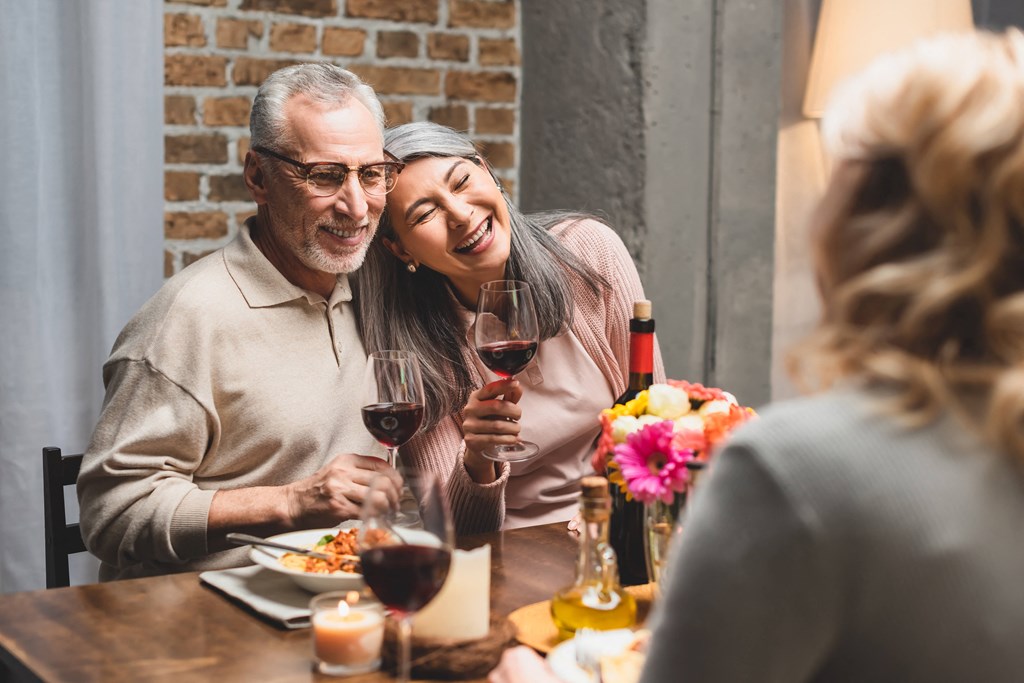older couple laughing at dinner