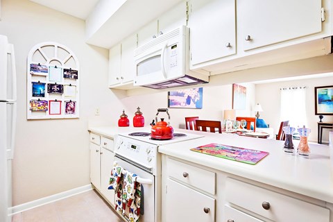 a kitchen with white cabinets and a stove and a microwave