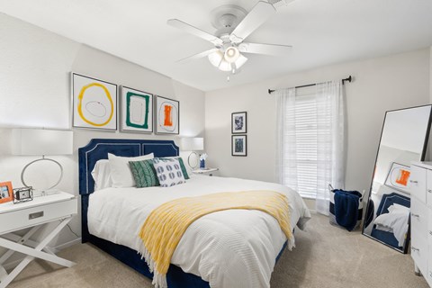 a bedroom with a large bed and a ceiling fan
