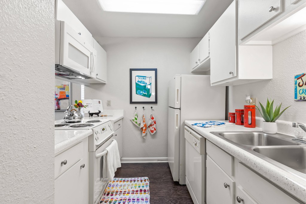 a kitchen with white cabinets and a sink and a refrigerator