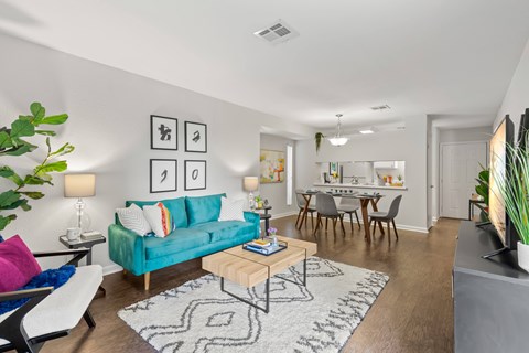 A living room with a blue couch and a rug.