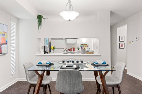 A dining room with a glass table and chairs.