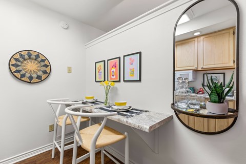 A dining area with a white table and chairs.