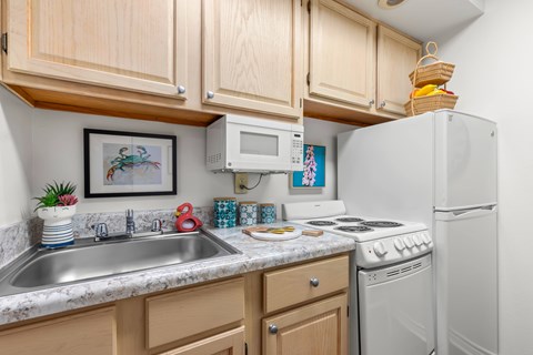 A kitchen with wooden cabinets and a white refrigerator.