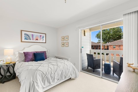 A bedroom with a large bed and a balcony.