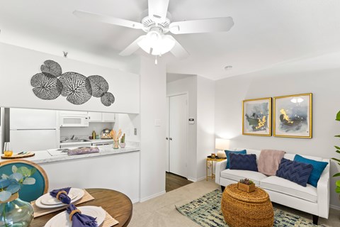 A living room with a white couch and a ceiling fan.