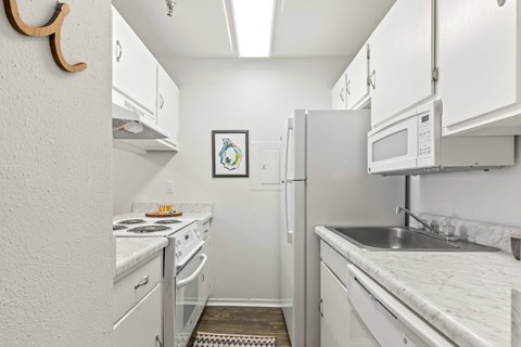 A small kitchen with white appliances and cabinets.
