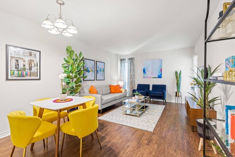 A living room with a white table and yellow chairs.