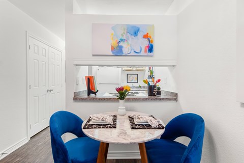 A dining room with a table and chairs.