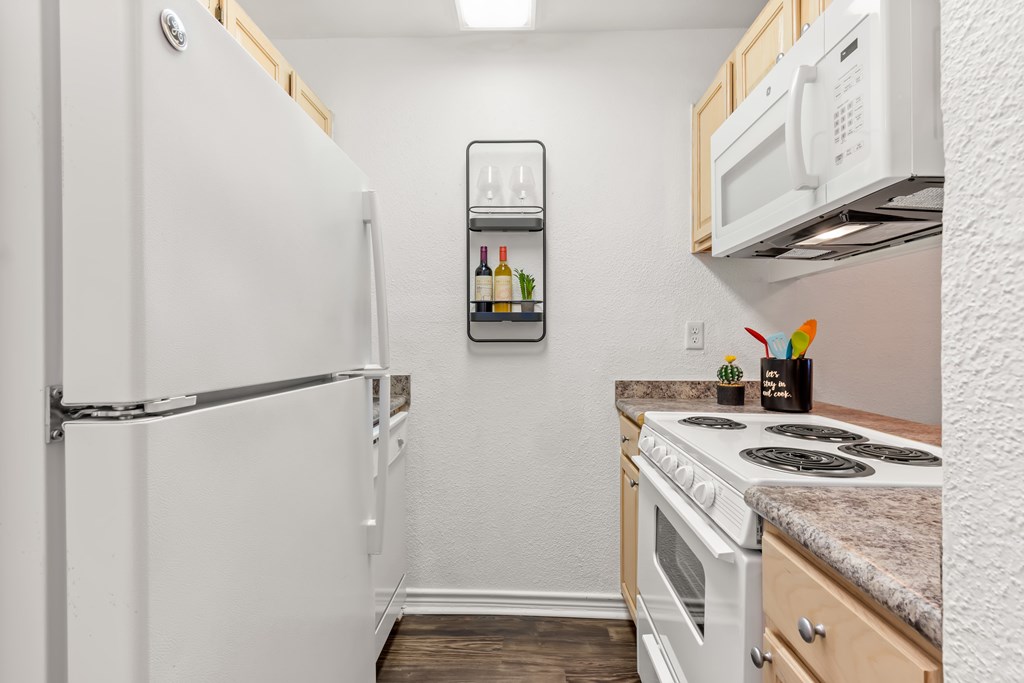A small kitchen with a white refrigerator and a white stove.