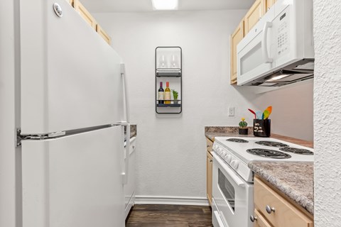 A small kitchen with a white refrigerator and a white stove.