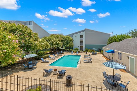 A pool surrounded by chairs and umbrellas.