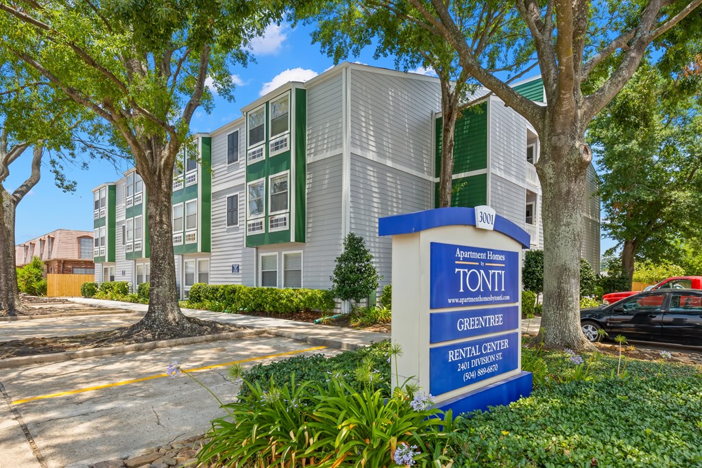 A sign for Apartment Home by Tonti in front of a building.