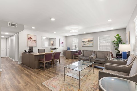 A spacious living room with a glass coffee table and a variety of seating options.