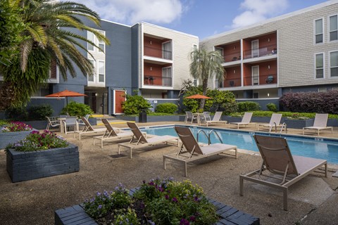 A pool area with lounge chairs and a small pool.