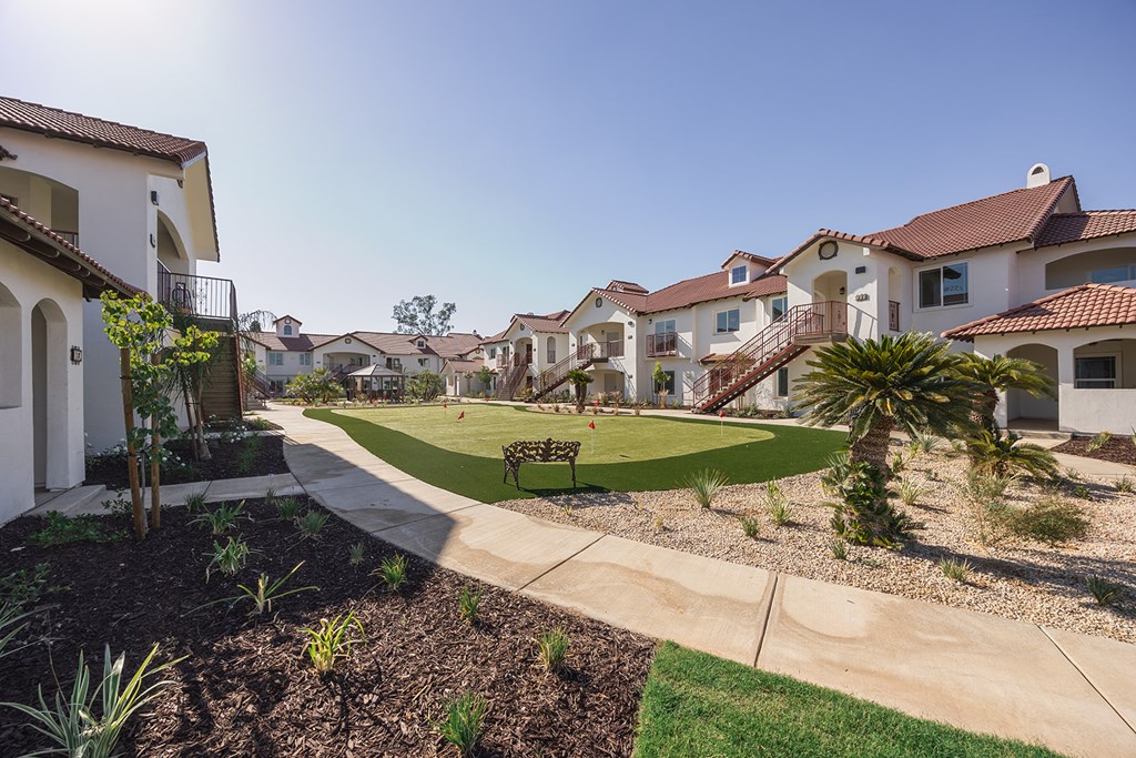 A sunny day in a residential neighborhood with houses and a park.