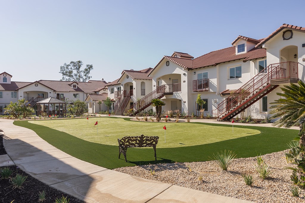 A row of houses with a green lawn in front.