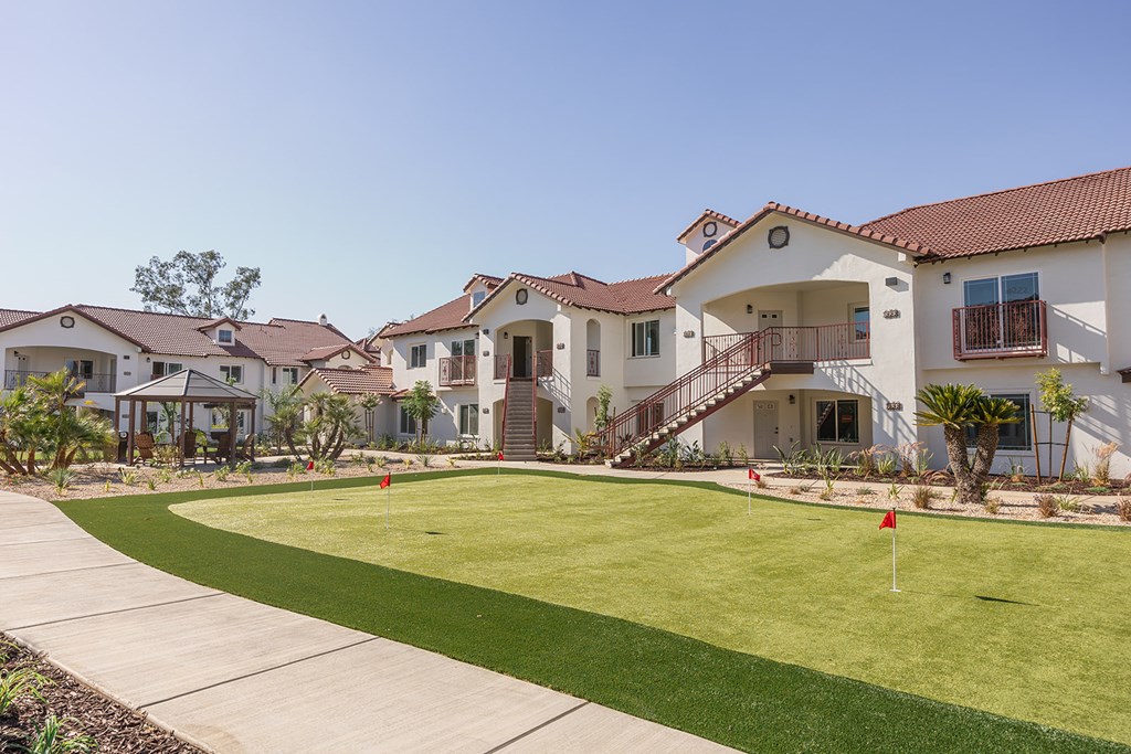 A row of houses with a green lawn in front.