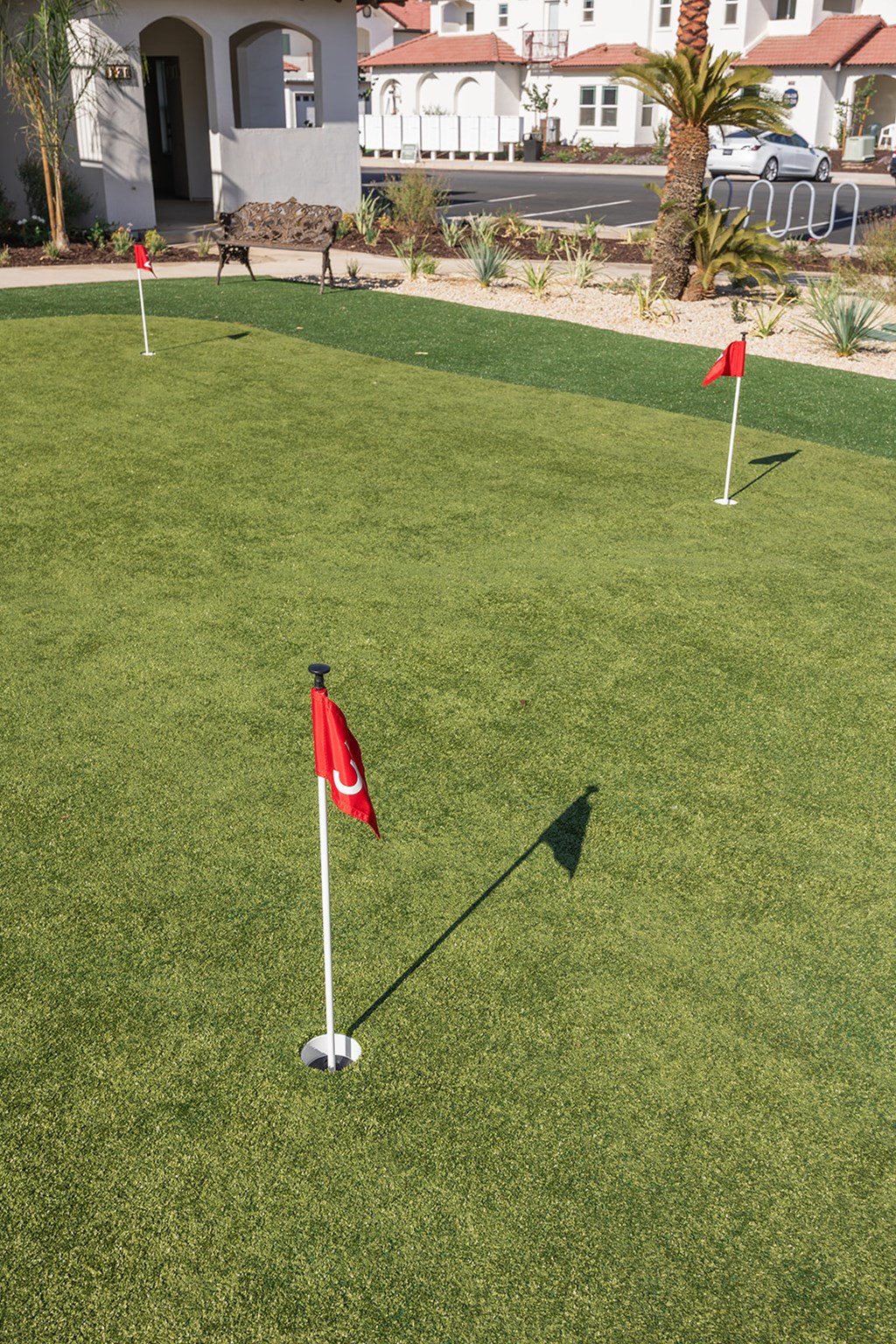 A golf course with a red flag on the green.