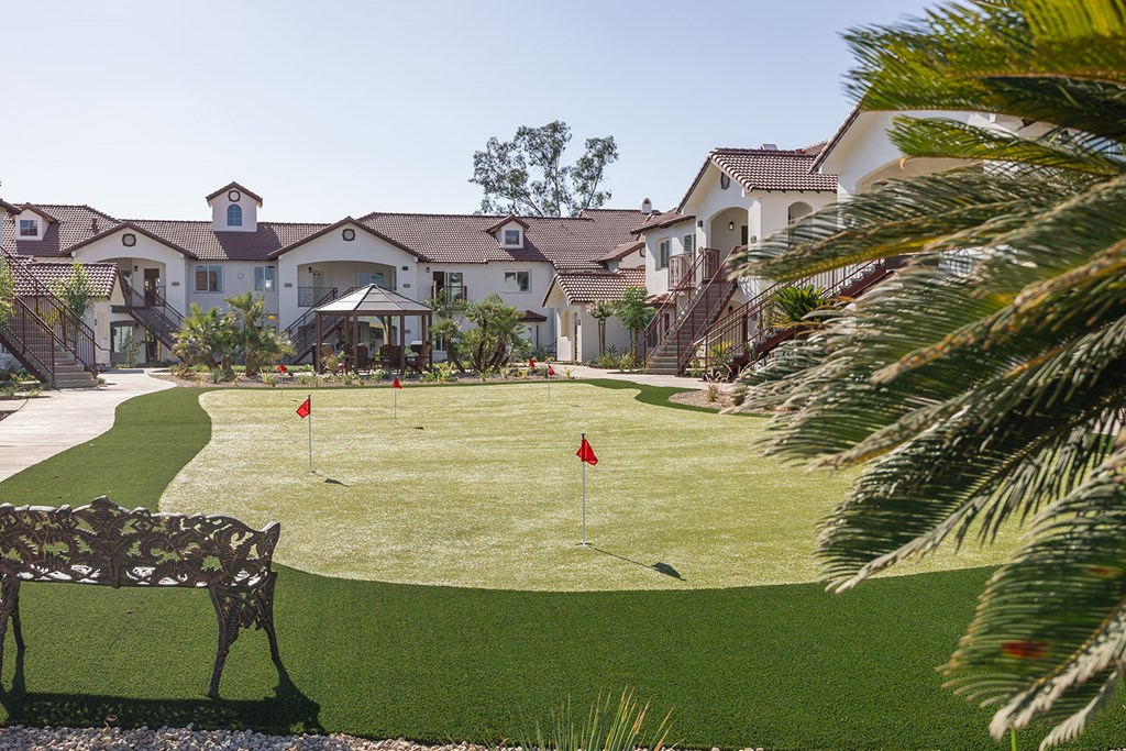 A golf course is in the front of a large house.