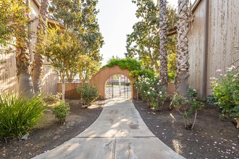 A garden pathway leads to a brick archway.