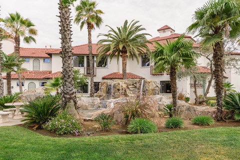 A house with a red tile roof and a palm tree in front.