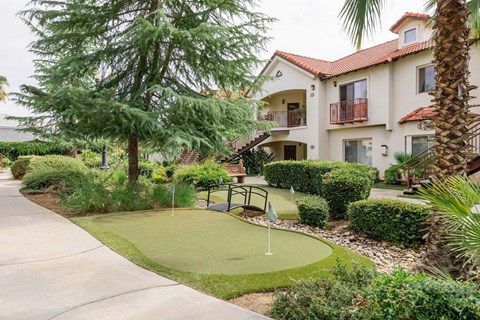 A small putting green in front of a building.