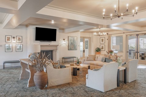 A living room with a fireplace and a television on the wall.