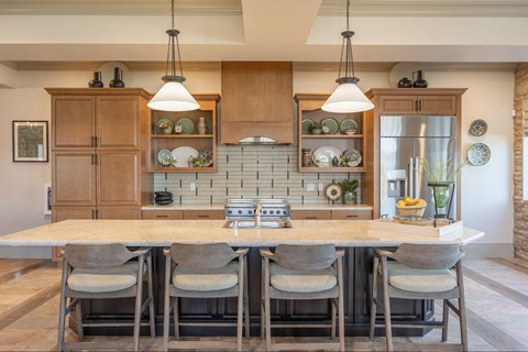 A kitchen with a table and chairs in front of it.