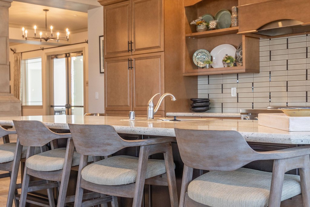 A kitchen with a sink, chairs, and cabinets.at The Villas at Ellis Manor, Fresno
