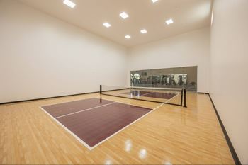 A squash court with a wooden floor and a glass backboard.at The Villas at Ellis Manor, California
