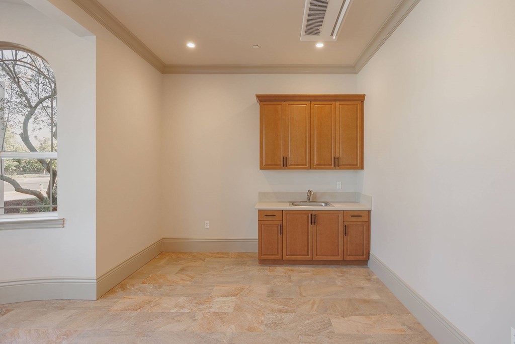 A kitchen with wooden cabinets and a marble floor.at The Villas at Ellis Manor, California, 93720