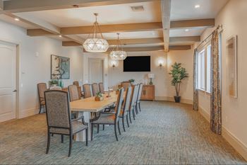 A large dining room with a long table and chairs.at The Villas at Ellis Manor, California, 93720