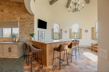 A bar area with a stone wall and a TV.at The Villas at Ellis Manor, California, 93720