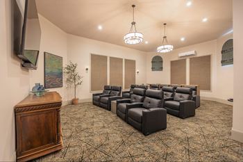 A room with a carpeted floor and a row of black leather chairs.at The Villas at Ellis Manor, Fresno California