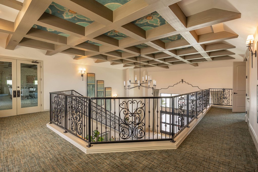 A large room with a balcony and a chandelier.at The Villas at Ellis Manor, California