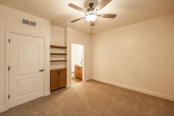 A room with a ceiling fan and carpeted floor.at The Villas at Ellis Manor, Fresno, CA