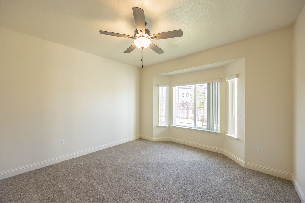 A room with a ceiling fan and carpeted floor.at The Villas at Ellis Manor, Fresno