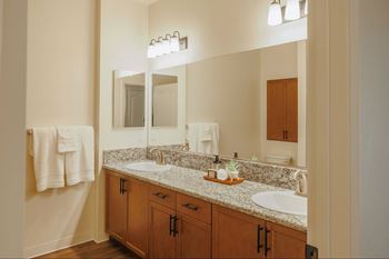 A bathroom with a white sink and a mirror above it.at The Villas at Ellis Manor, California
