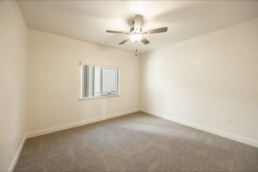 A room with a ceiling fan and a window.at The Villas at Ellis Manor, California