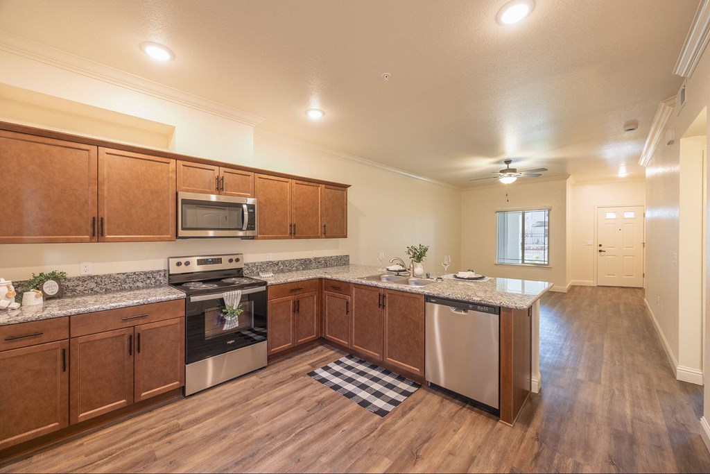 A kitchen with wooden cabinets and stainless steel appliances.at The Villas at Ellis Manor, Fresno, CA 93720