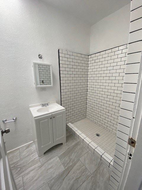 a white bathroom with a sink and a shower