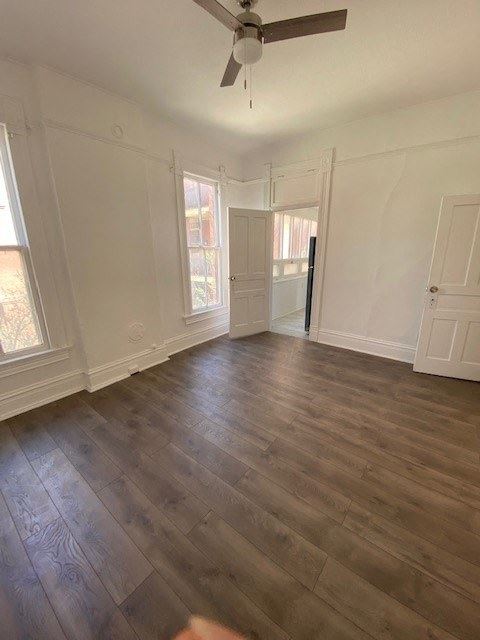 an empty living room with white walls and a wooden floor