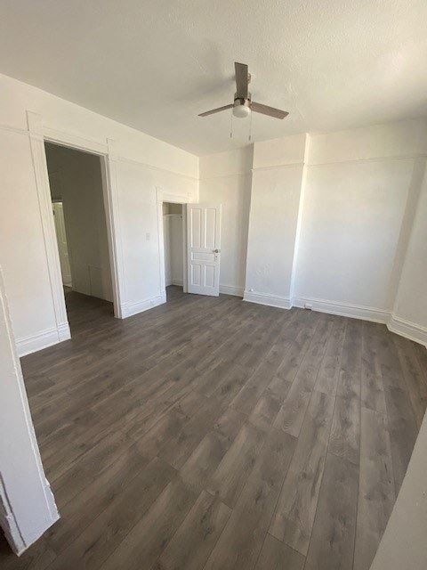 an empty living room with white walls and a ceiling fan