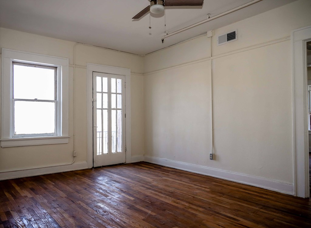 an empty living room with white walls and wood floors